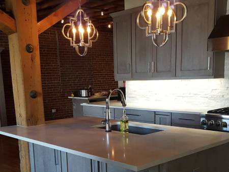 Modern kitchen with island and pendant lights.